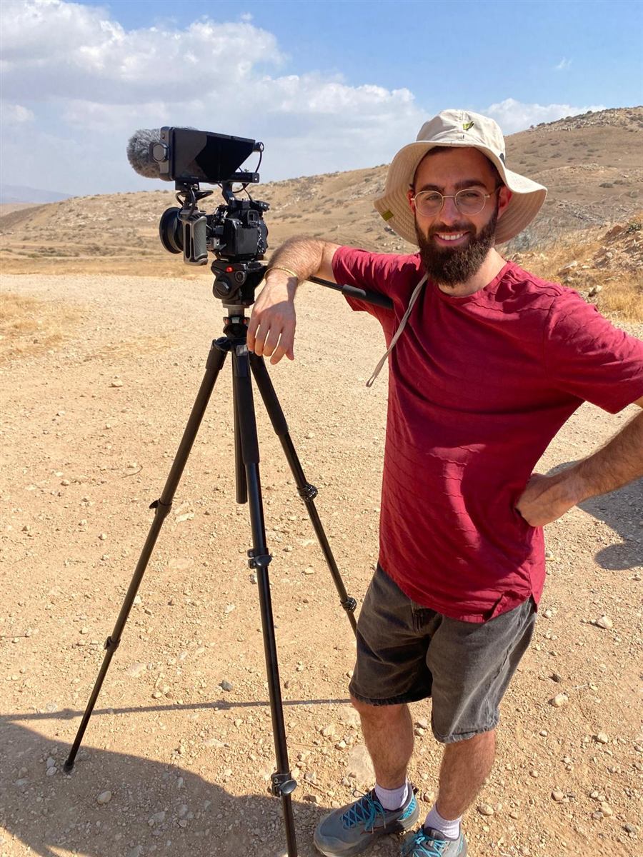שקד ברנד עם מצלמה על חצובה, בשטח